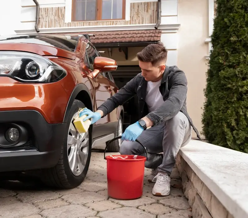 Lavage auto à domicile Saint-Symphorien-de-Thénières : professionnel intervenant sur un véhicule